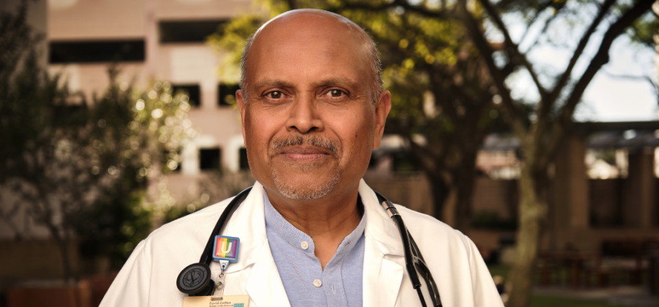 Dr. Arun Karlamangla standing outside on the UCLA campus with a smile