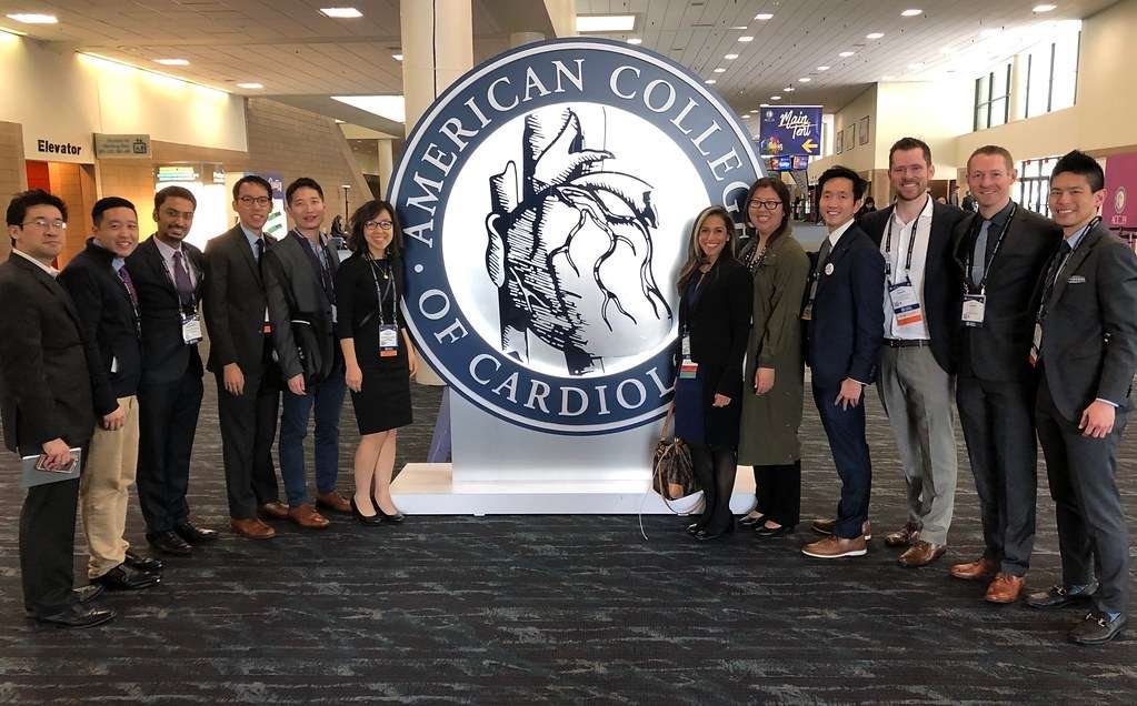 Doctors standing around American College of California Sign
