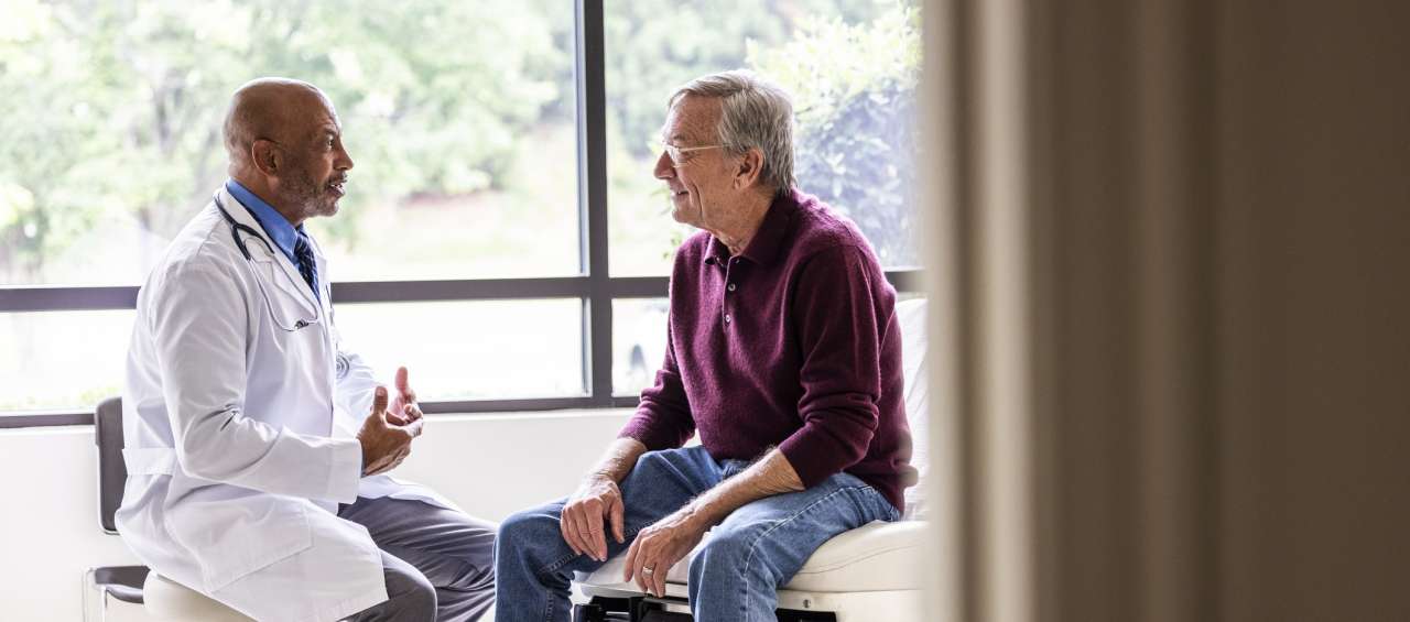 Male doctor talking to a patient during a visit