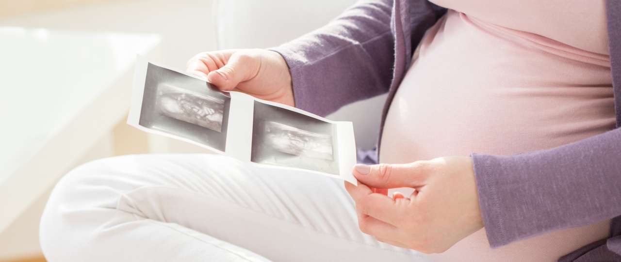 Pregnant woman looking at sonogram pictures