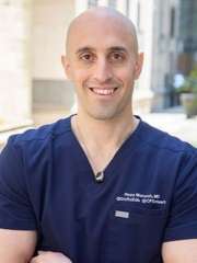 headshot of doctor Reza Manesh in blue scrubs