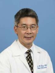 Dr Eric Cheng wearing a white doctors coat and smiling at the camera