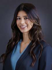Emery Dutta headshot, wearing a light blue shirt and dark blue coat.