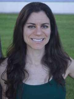 A portrait of Dana Hunnes, a senior dietitian with long dark hair, smiling at the camera outdoors.