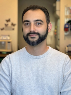 Headshot of a Dr. Grigor Varuzhanyan with short dark hair and trimmed beard wearing light gray sweater