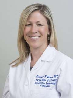 Lindsay Kroener smiling in a white lab coat headshot