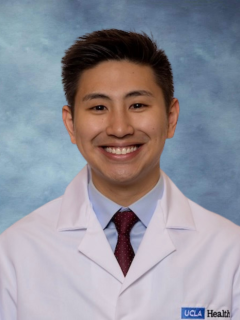 Dr. Jason Tang wearing a lab coat in front of a blue background