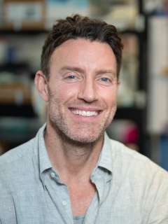 Dr. David Nathanson stands smiling in his lab