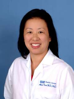 Alice Kuo in a white lab coat against a blue background.