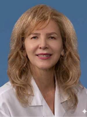 Renata Pereira smiling in white coat on blue background