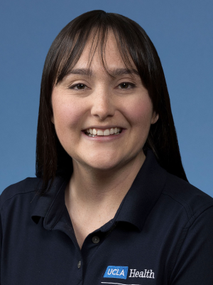 Norell Oliver wearing navy UCLA Health polo against blue background.