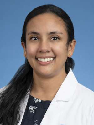 Niroshi Senaratne, PhD in a white lab coat