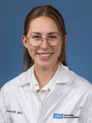 Head shot of Clare Schrodt in white lab coat, smiling at camera
