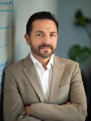 Dr. Benjamin Ellingson standing with his arms folded and looking at the camera