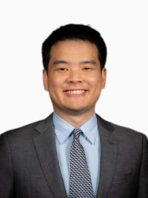 Charley Yan smiling in a suit and tie