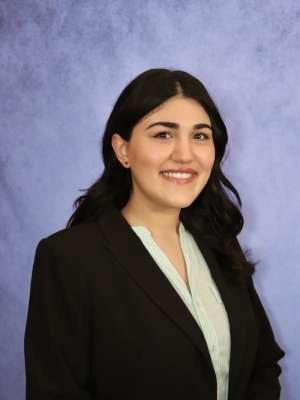 Three-quarters shot of Vista Farkhondeh, MD, in business attire, smiling at camera