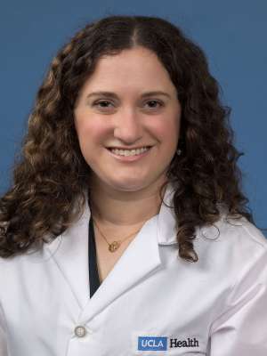 Head shot of Alexa Ciarolla in white lab coat, smiling at camera