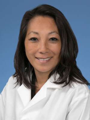 Sue Kang, PhD, FACMG in a white lab coat