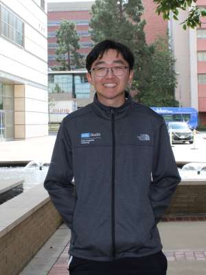 Tyler Kim smiling outside RRMC in jacket.