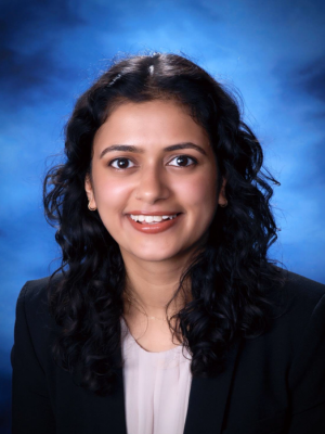 Head shot of Anjali Upadhyaya in business attire, smiling at camera