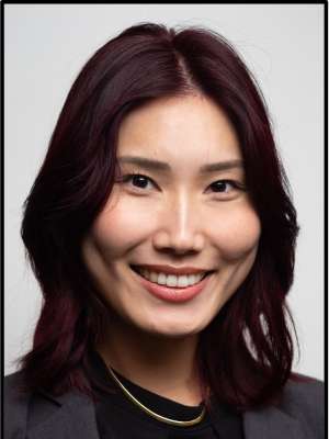 headshot of Ellie Ok with a black blouse in front of a white background