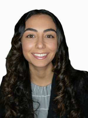 Smiling professional headshot of woman with long dark curly hair wearing a blazer.
