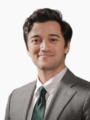 Kevin Senanayake headshot in gray suit and green tie, slight smile.