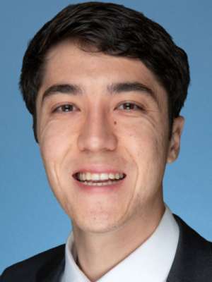 Smiling man in suit and tie against blue background