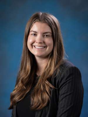 Head shot of Chloe Villars, MD in a dark top, smiling at camera