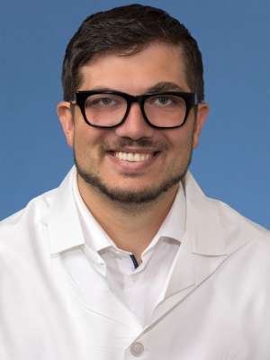Head shot of Arthur Gribachov in white lab coat, smiling at camera