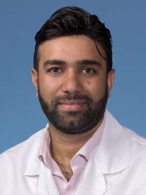 Adil Bhat, PhD in a white lab coat
