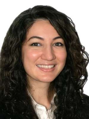 Smiling woman with dark curly hair, professional headshot