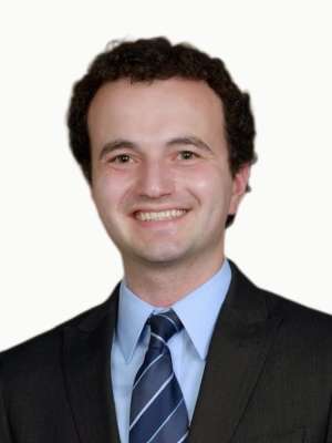 Dennis Pales smiling headshot wearing suit and tie.