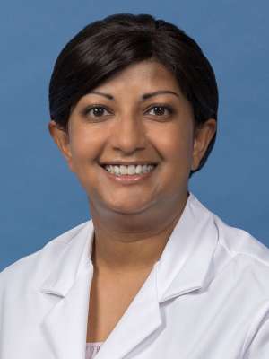 Suki Chandrasekaran, PhD in a white lab coat