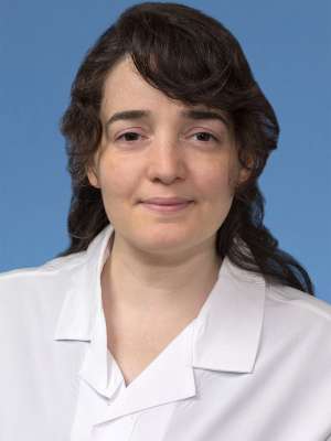 Head shot of Isil Yenice Balevi in white lab coat, smiling at camera