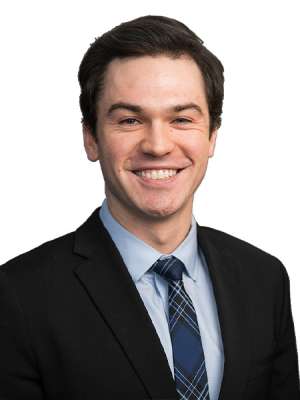Doctor Strong in a black suit, light blue shirt, and blue flannel tie with a white background
