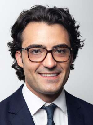 Headshot of Sam Olson in black suit