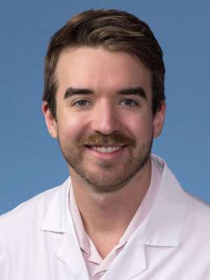 Kallen Schwark, MD, PhD in a white lab coat
