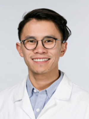Portrait of a doctor with brown hair wearing glasses