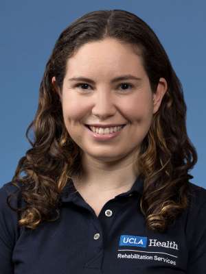 Headshot of Rebecca Altman wearing a UCLA Health polo shirt against a blue background.