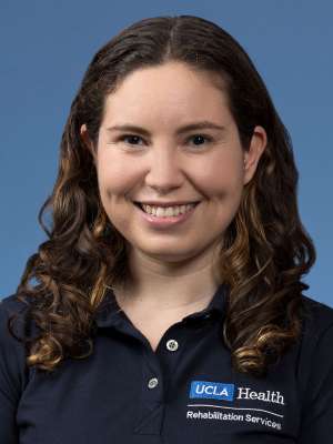 Headshot of Rebecca Altman wearing a UCLA Health polo shirt against a blue background.