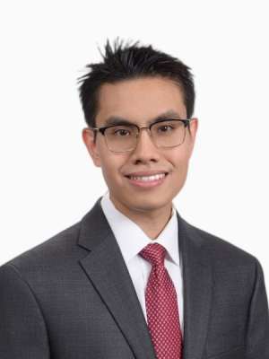 Young man in suit and red tie smiling for professional headshot