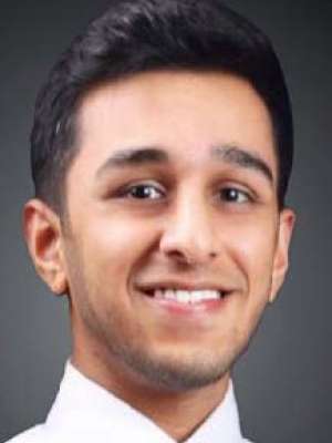 Akash Halgur, a young man with dark hair, smiling confidently at the camera. He wears a white shirt and a patterned tie.