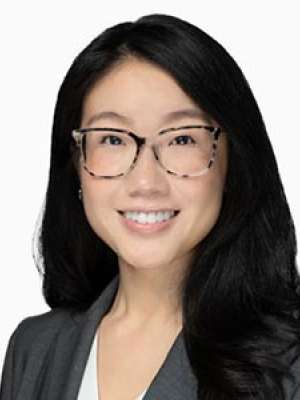 Margaret Wang, smiling headshot wearing glasses and a blazer.