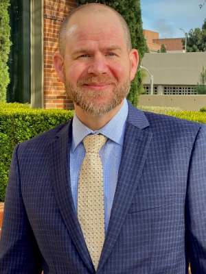 Smiling man wearing suit outdoors. 