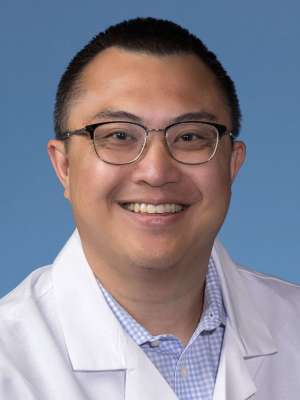 Joshua Nguyen, DO in a white lab coat