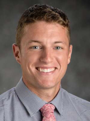 Bryan Myers Headshot in an indoor setting with a gray baackground