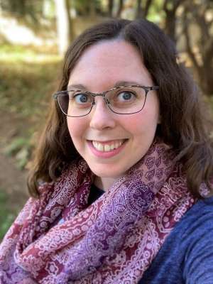 headshot of Kelsey Jarrett in a purple scarf and blue shirt