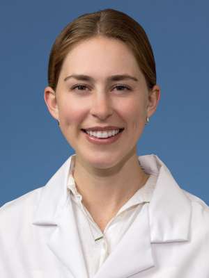 Head shot of Clare Schrodt, MD in white lab coat, smiling at camera