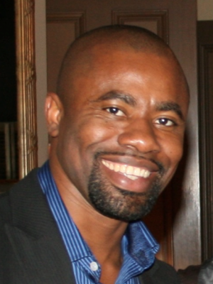 Gerald Asare Bempong headshot, wearing a blue stripped button up shirt and a black suit jacket.